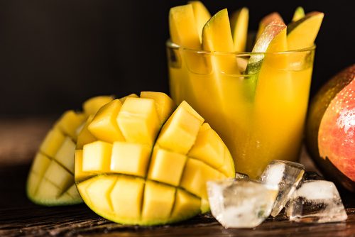 Mango juice and mango on wood table